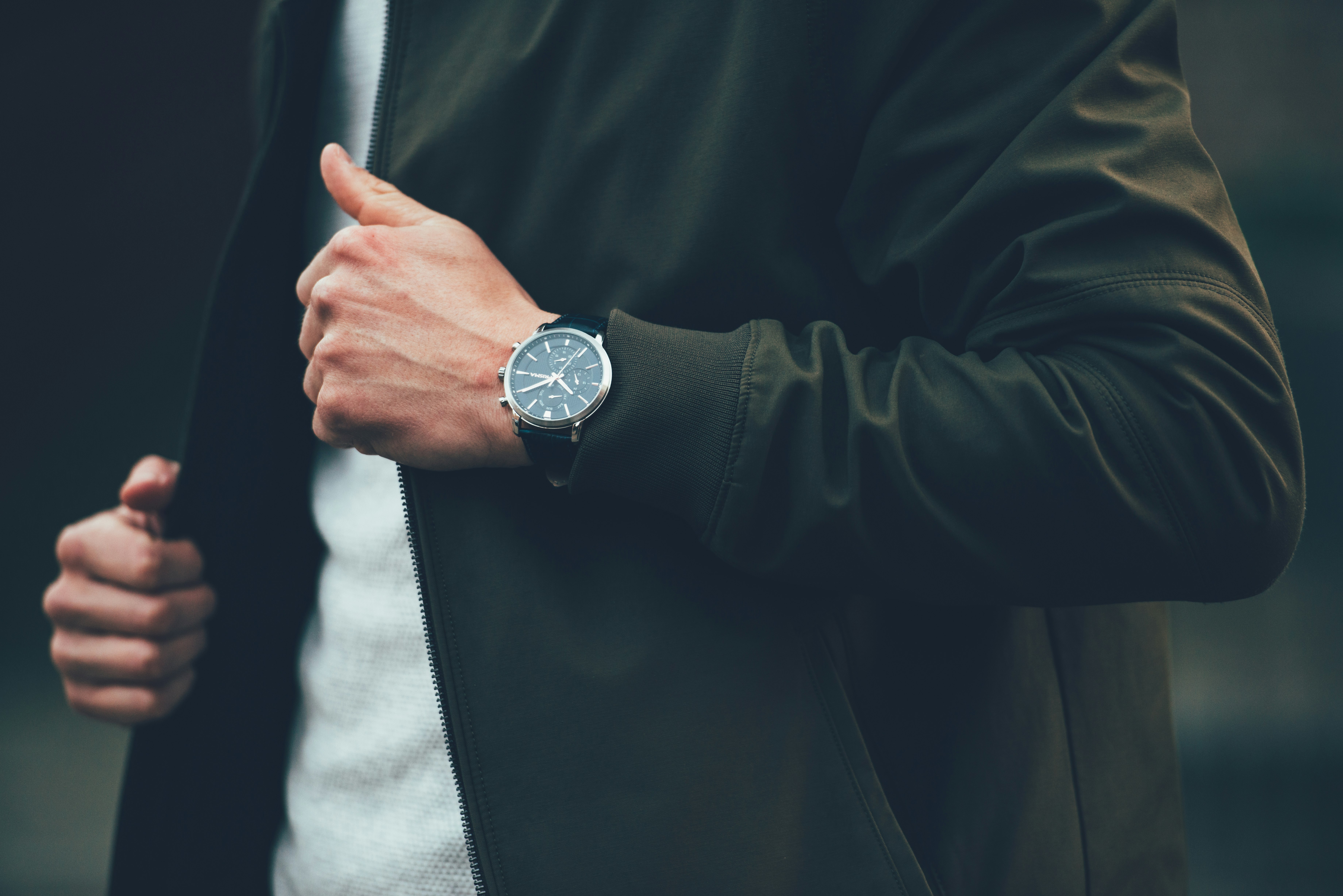 man wearing black jacket and holding it